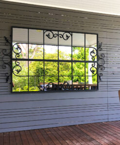 Scrolled Gate outdoor mirror on slatted wall