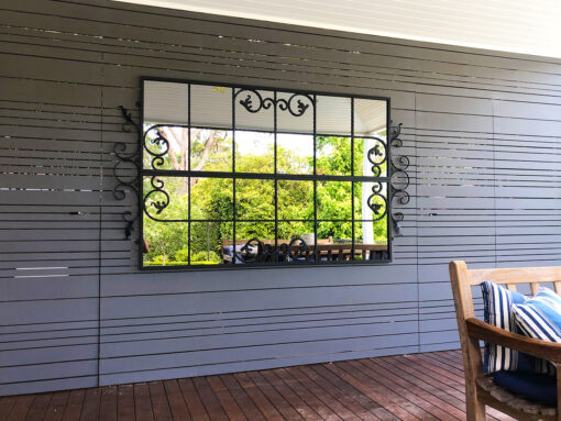 Scrolled Gate outdoor mirror on slatted wall
