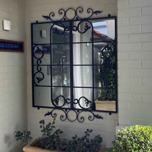 Our Scrolled Gate design outdoor mirror brings light and style to this alcove at the front door of this Northshore home.#outdoormirrors #backyardgoals #outdoorliving #outdoor #alfresco #gardenlife  #beautifulplaces #outdoordesign  #stylishhomes #outdoormirrors #australiandesign #gardenaccessories #gardendesign #welovestyle #outdoorstyle #lovelifeoutdoors #stylishaccessories #gorgeousgarden #exteriordesign #outdoorspace #landscapearchitecture #outdoorliving #landscapedesigner #australiandesigner #landscapedesign